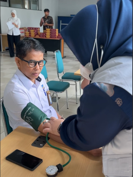 Bapak Solikan, Direktur Utama PT Tracon Industri sedang melaksanakan tensi darah